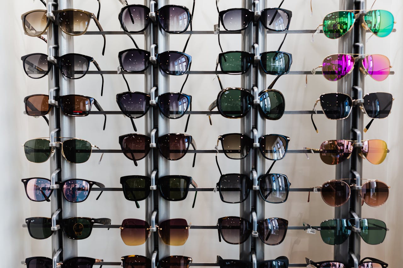 Variety of sunglasses displayed on racks in an indoor eyewear shop setting.